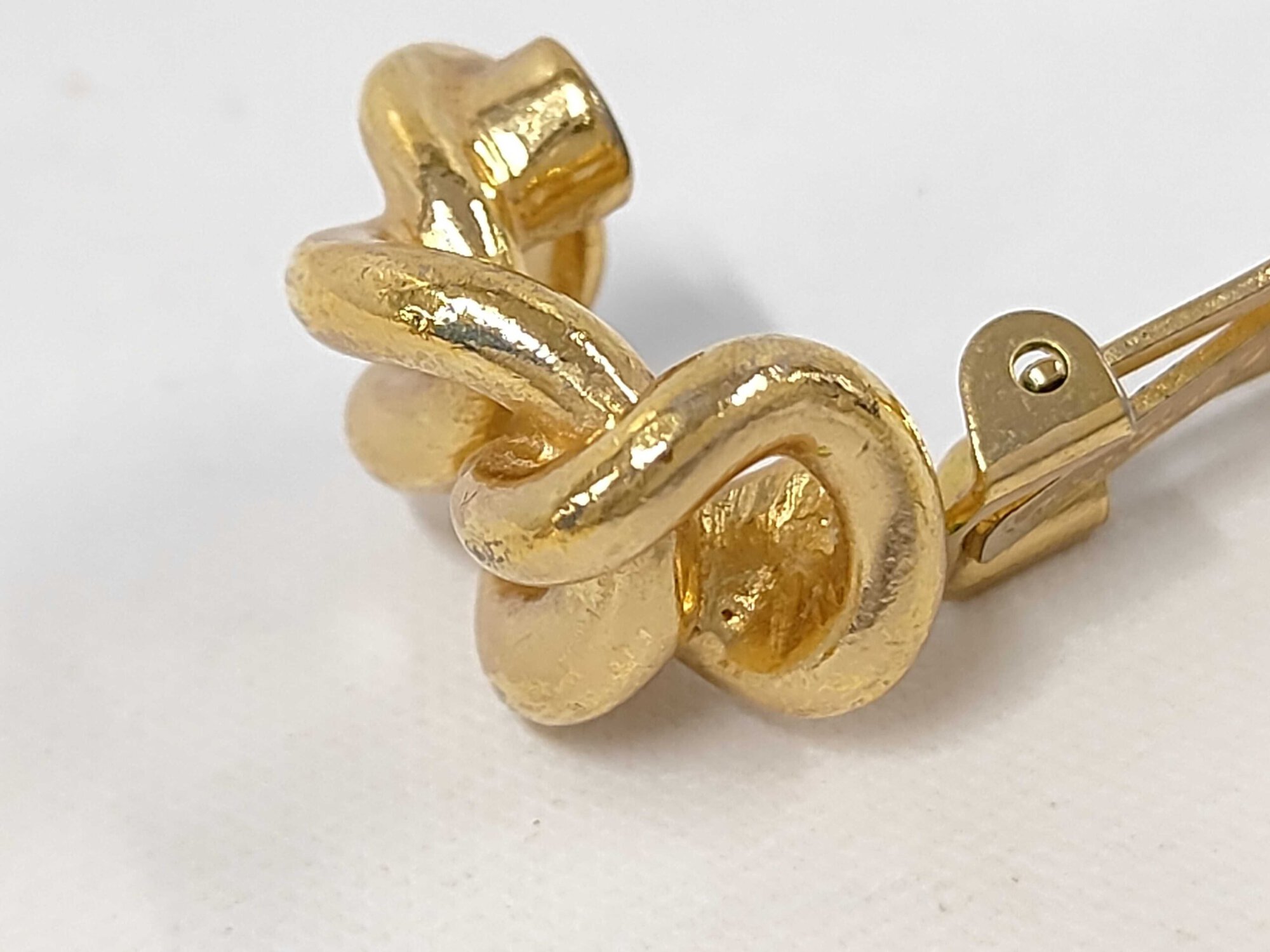 Close-up perspective of the front intertwined twist knot metal detailing.