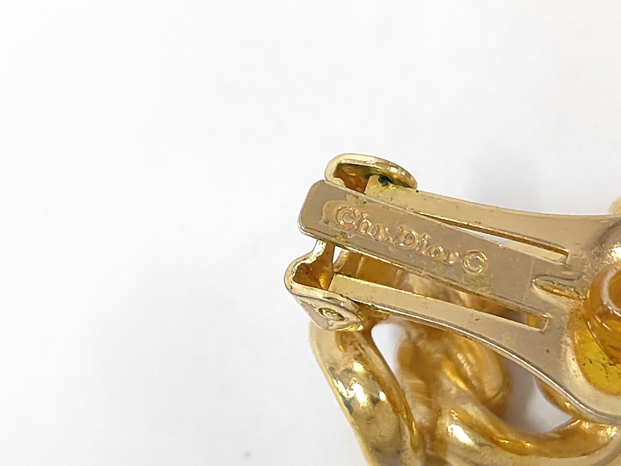 Macro detail of the Chr.Dior copyright hallmark stamped on the clip arm.
