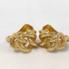 Front view of Christian Dior gold-tone twist knot clip-on earrings on a white surface.