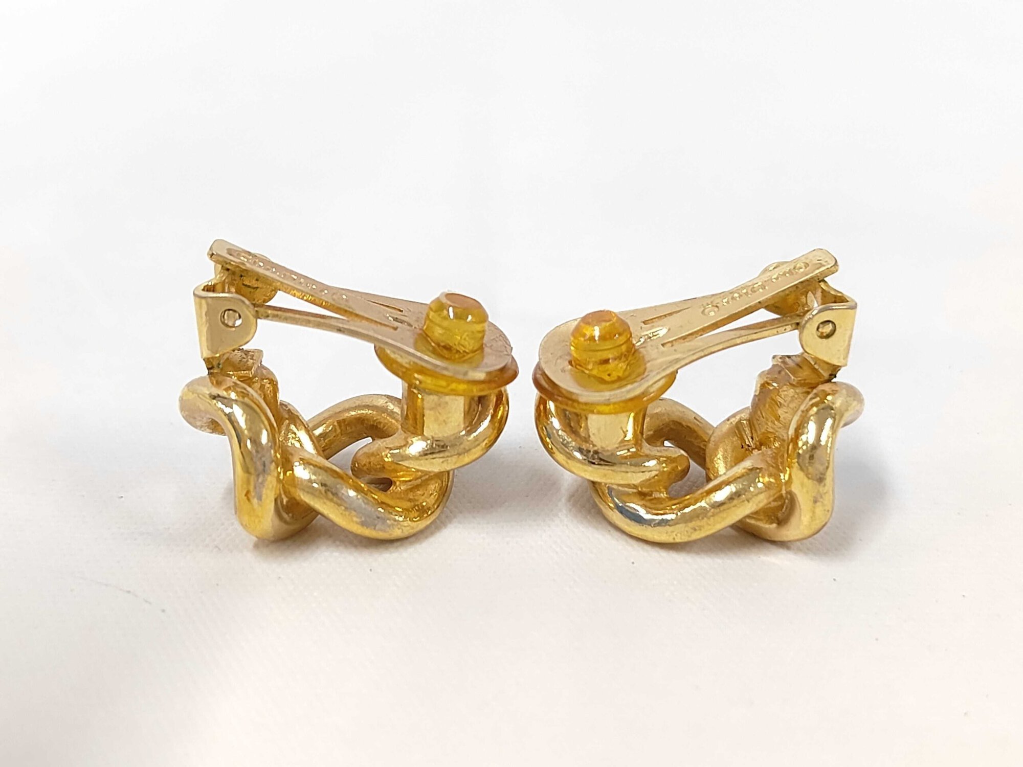 Rear view of Christian Dior earrings showing paddle clips with yellow comfort cushions.