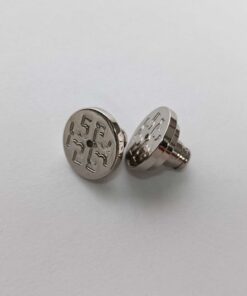 Close-up view of Tory Burch disc earring backings with embossed logo detailing
