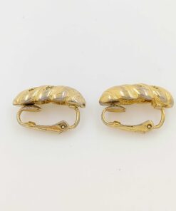 Side profile view of Christian Dior gold-tone earrings with paddle clips closed.