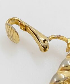 Close-up view of the earring clip hinge mechanism and curved paddle lever.