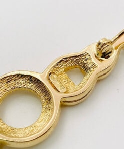 Close-up of textured reverse showing Dior copyright hallmark cartouche and rollover safety clasp mechanism.