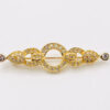 Front view of Christian Dior gold-tone horizontal bar brooch with open circle center and clear rhinestone accents.
