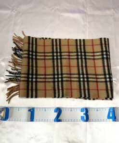 Folded Burberrys scarf laid horizontally alongside a measuring tape.