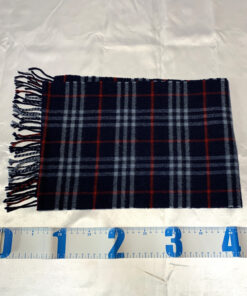 Burberrys navy check scarf folded widthwise aligned with a measuring tape.