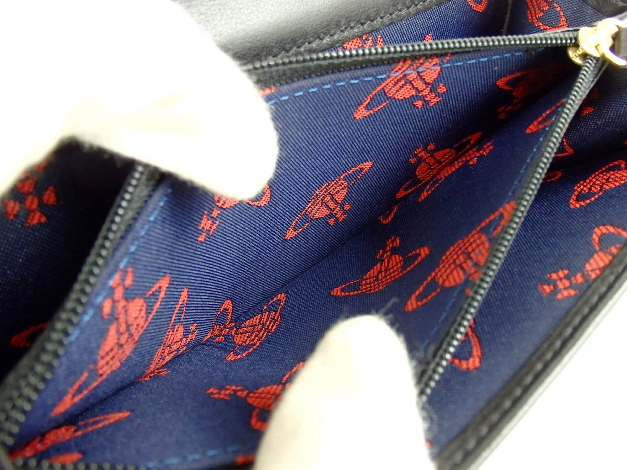 Close-up of red printed Orb textile lining and gold-tone zipper pull