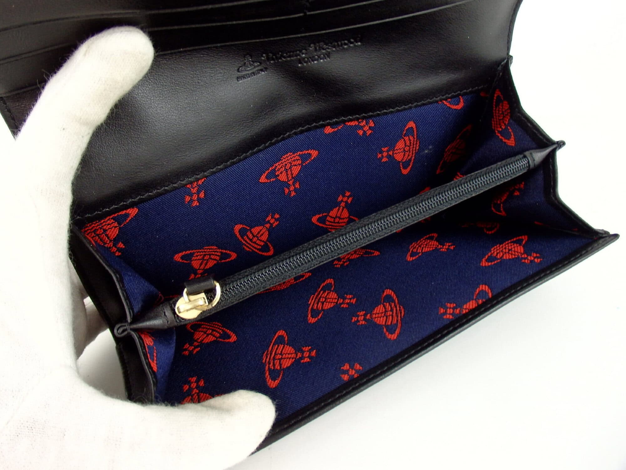 Expanded interior compartment view showing red Orb patterned lining and zip pocket