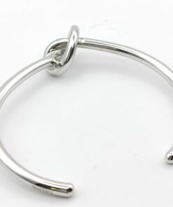Top-down view of open cuff silhouette showing central knot and band curve