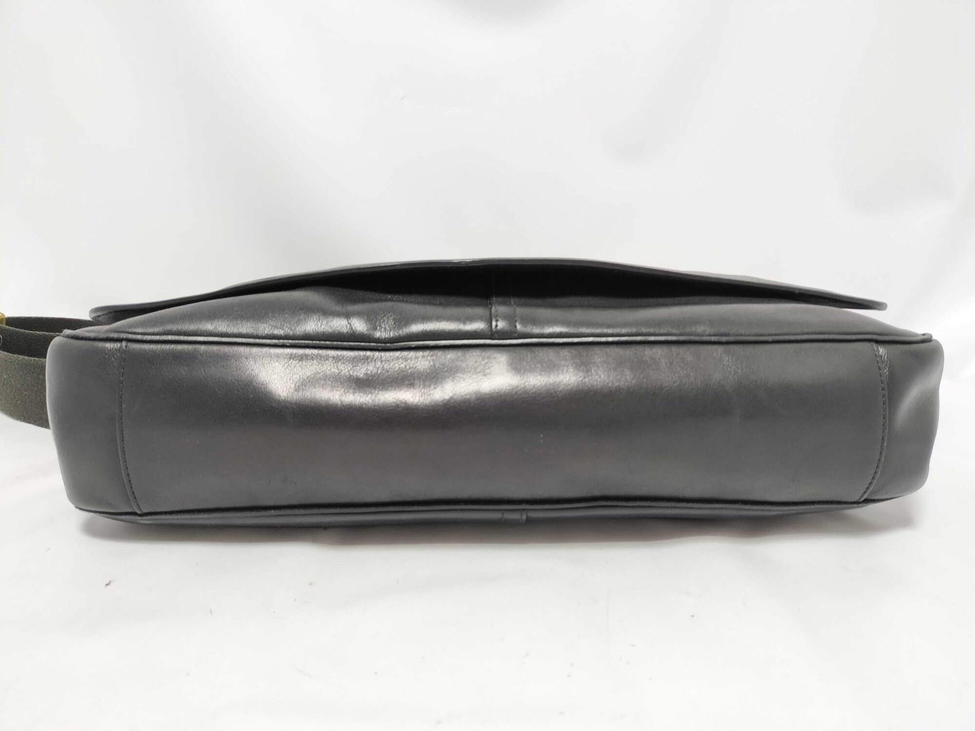 Bottom base panel of Coach black leather courier messenger bag.