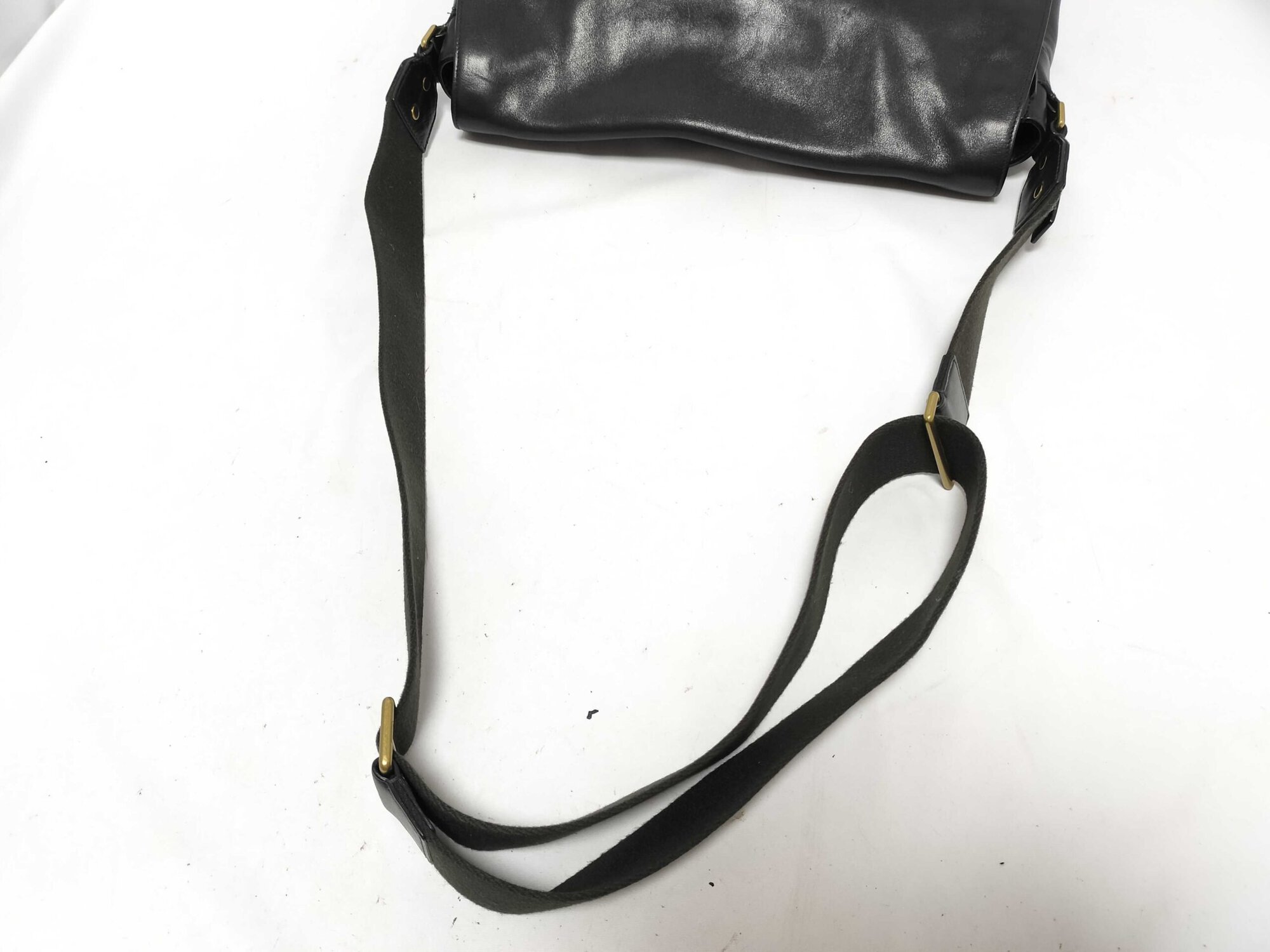 Full length of adjustable dark woven fabric webbing shoulder strap.