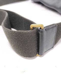 Close-up of brass-tone metal slider buckle on webbed strap.