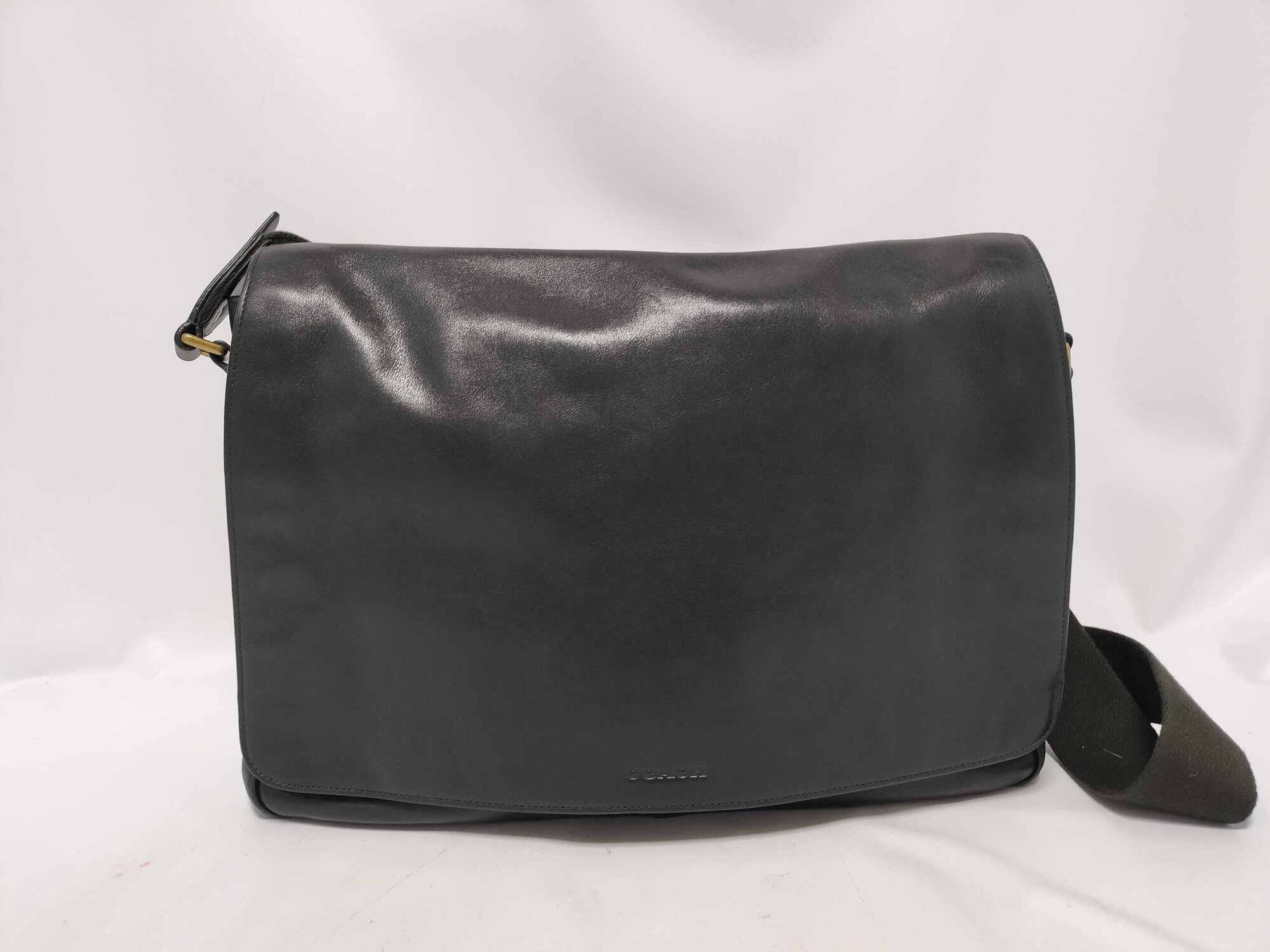 Front view of Coach Bleecker black leather courier messenger bag with flap closure.