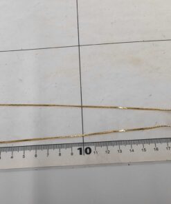 Givenchy necklace laid folded flat against a centimeter measuring grid mat.