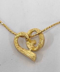Back of Givenchy gold-tone asymmetrical heart pendant showing textured finish and hallmark