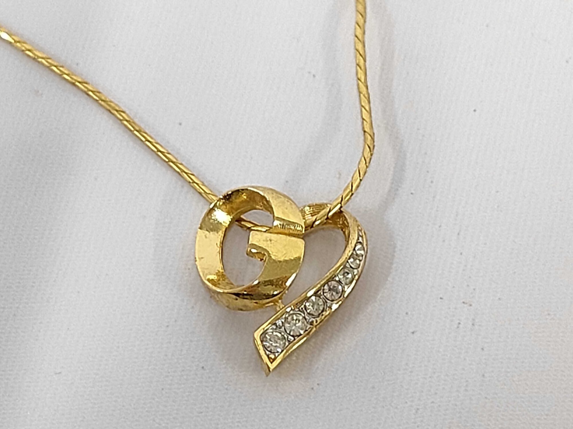 Givenchy gold-tone asymmetrical heart pendant necklace with G monogram and clear accents