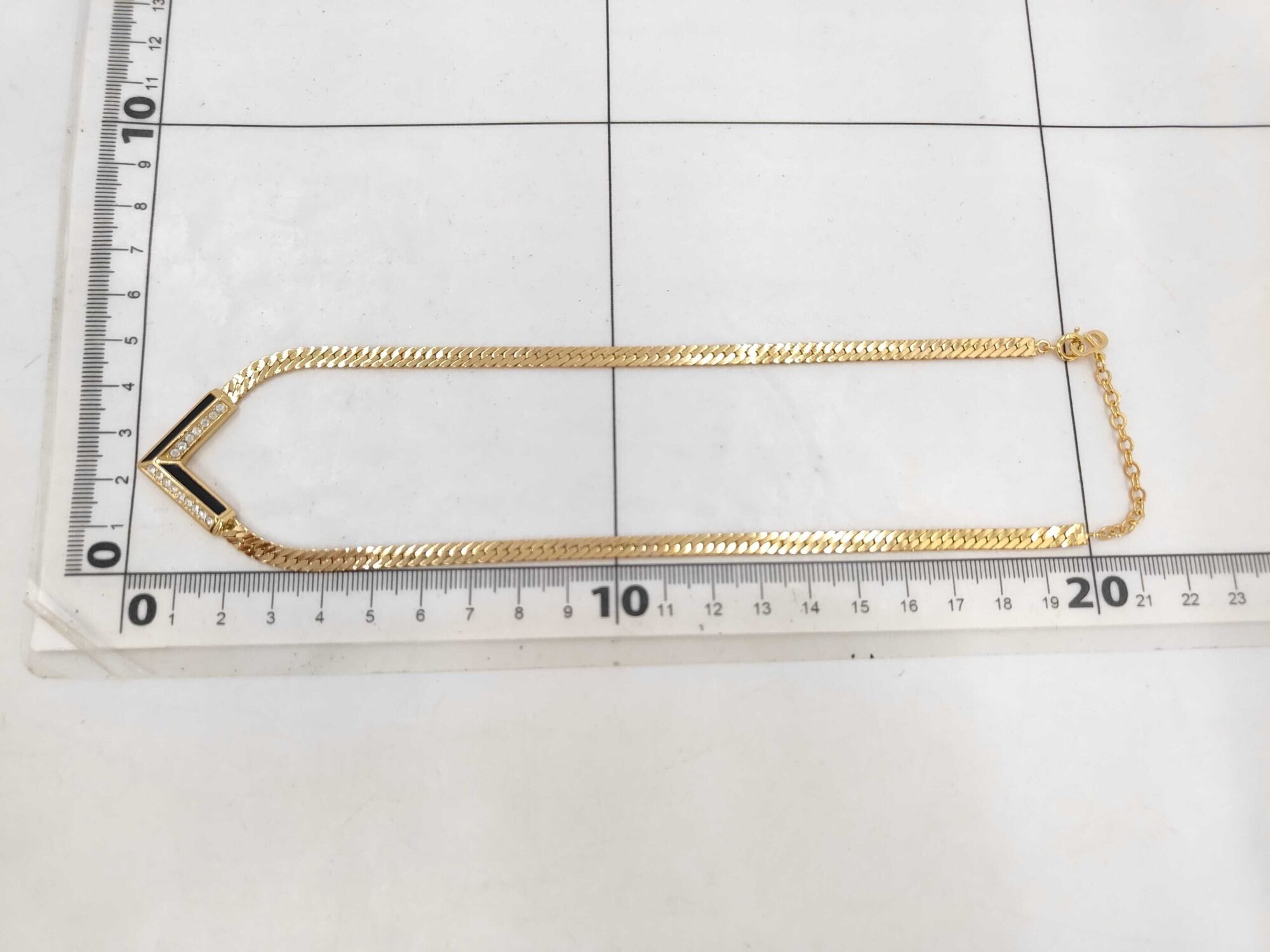 Christian Dior necklace displayed folded along a metric measurement grid.