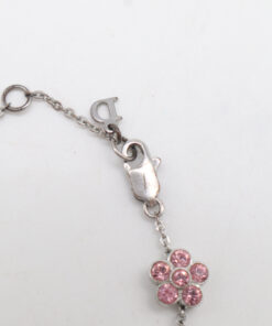 Close-up of the lobster claw clasp, Dior logo charm, and adjacent pink floral charm on chain.