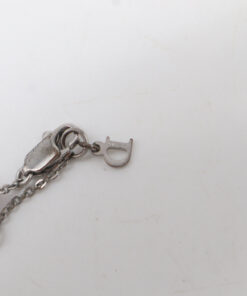 Close-up of the reverse side of the lobster clasp, extender chain, and engraved Dior letter charm.