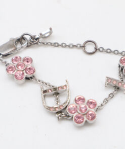 Macro view of the pink stone-set flower charms alongside the D and I letter charms on the silver-tone chain.
