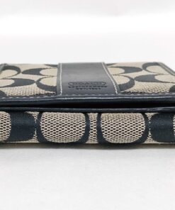 Top edge view of folded Coach wallet showing open bill compartment track.