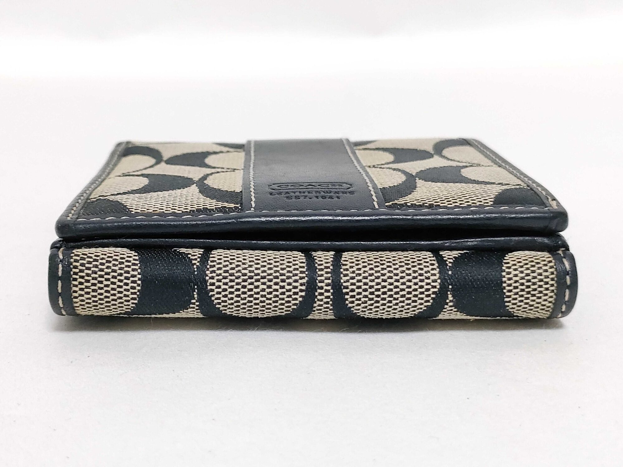 Top edge view of folded Coach wallet showing open bill compartment track.