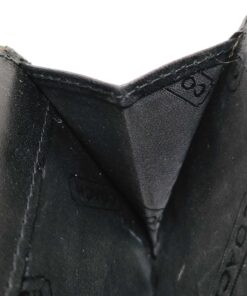 Gusseted accordion coin compartment interior showing black Coach logo textile lining.