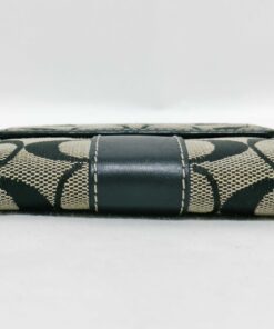 Bottom spine view of folded Coach Signature jacquard bifold wallet.