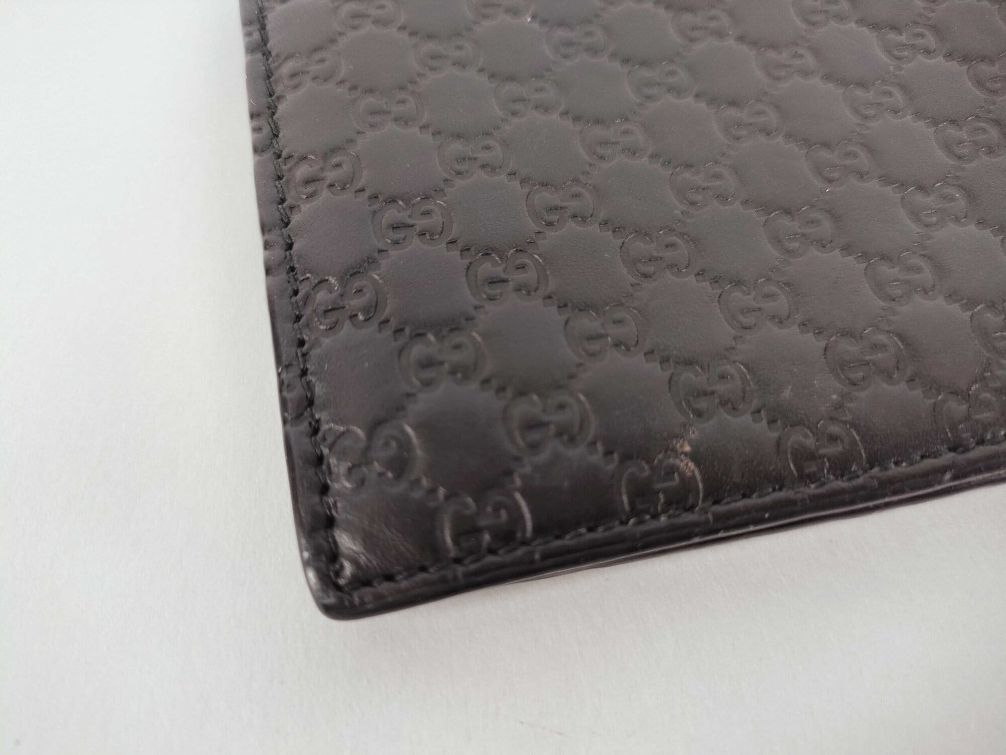 Macro close-up of Gucci Microguccissima embossed pattern and perimeter corner stitching