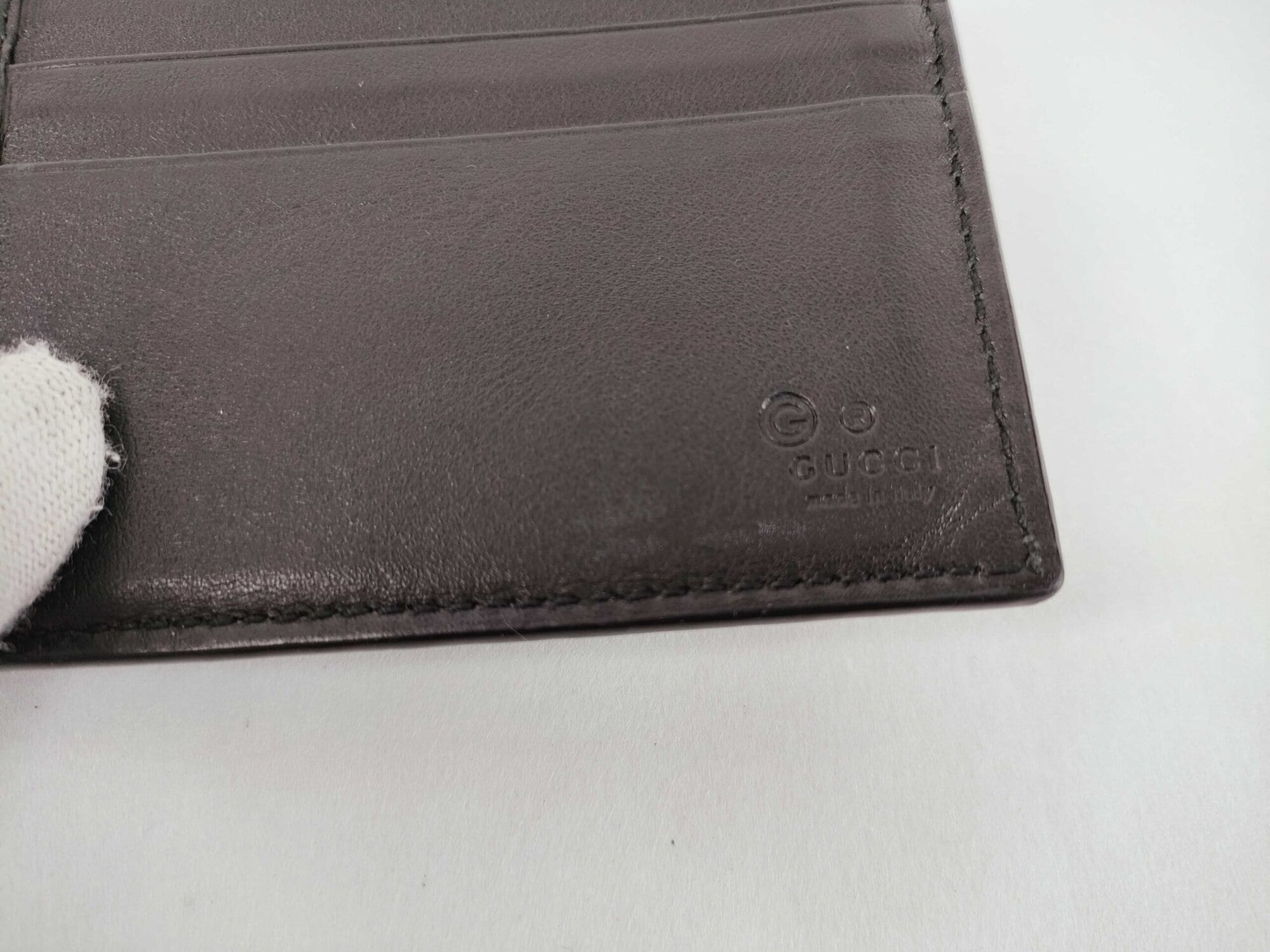 Close-up of debossed interior Gucci Made in Italy brand hallmark on black leather