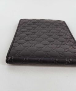 Side edge profile of folded black Gucci Microguccissima leather bifold wallet