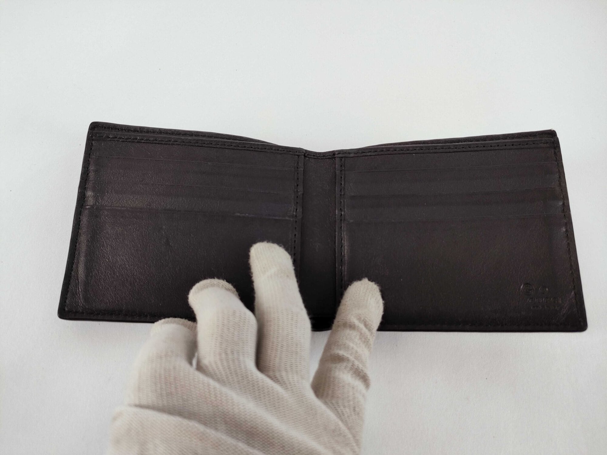 Full open interior of Gucci black leather bifold wallet showing card slots