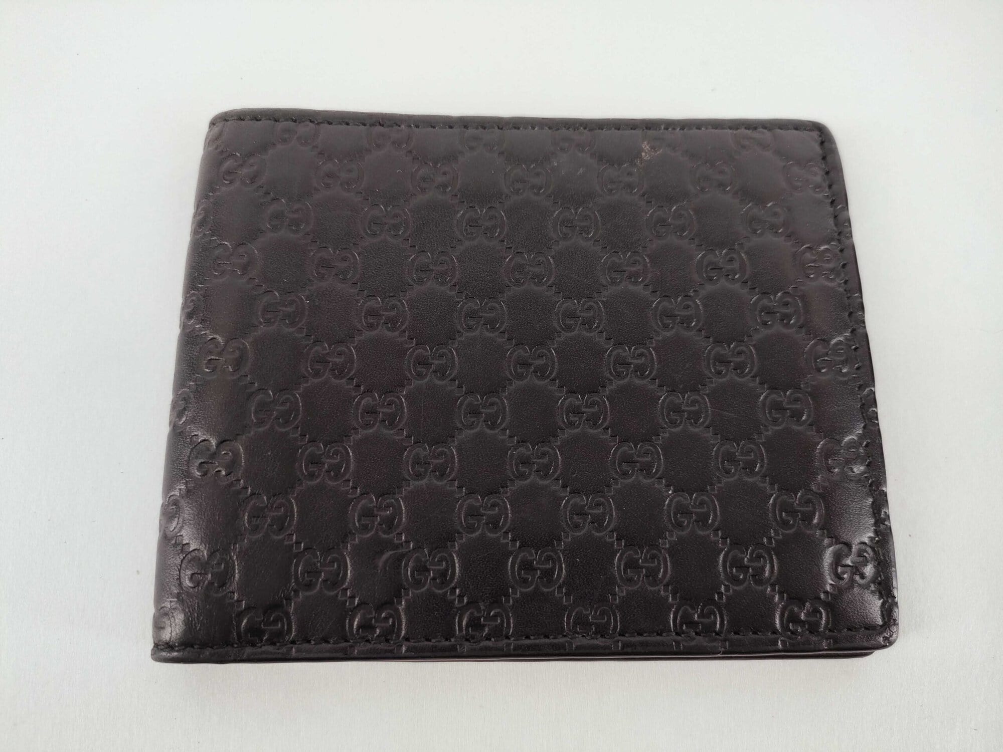Folded Gucci Microguccissima black leather bifold wallet front exterior view