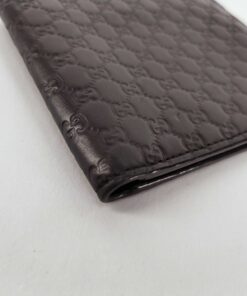 Angled view of folded Gucci Microguccissima black wallet spine and corner edge