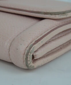 Close-up of lower corner showing rubbing and loss of finish along the edge glazing.