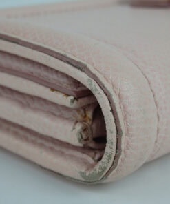 Detail view of the folded side gusset showing finish scuffing on the piping edges.