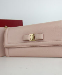Salvatore Ferragamo light pink Vara bow continental wallet displayed with its red box and card holder insert.