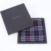 Burberry navy check pocket square resting folded inside open branded presentation box.
