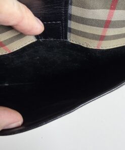 Interior of front exterior slip pocket showing black lining under leather tab.