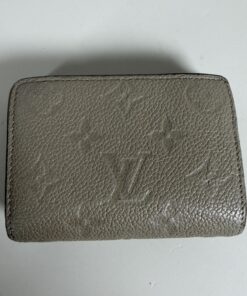 Front view of closed Louis Vuitton Monogram Empreinte Clea Wallet in taupe leather.