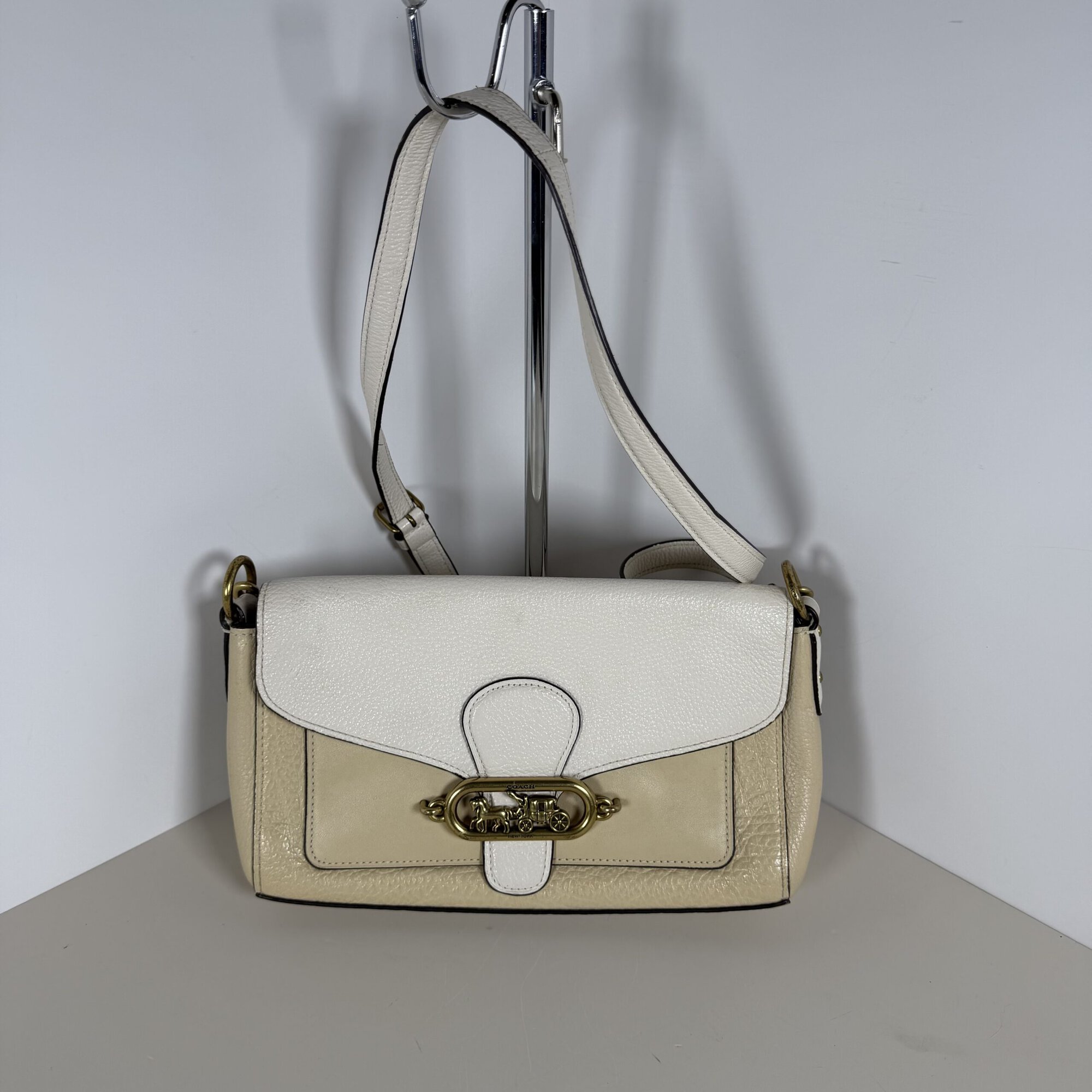 Coach Jade colorblock shoulder bag in white and beige hanging on display stand