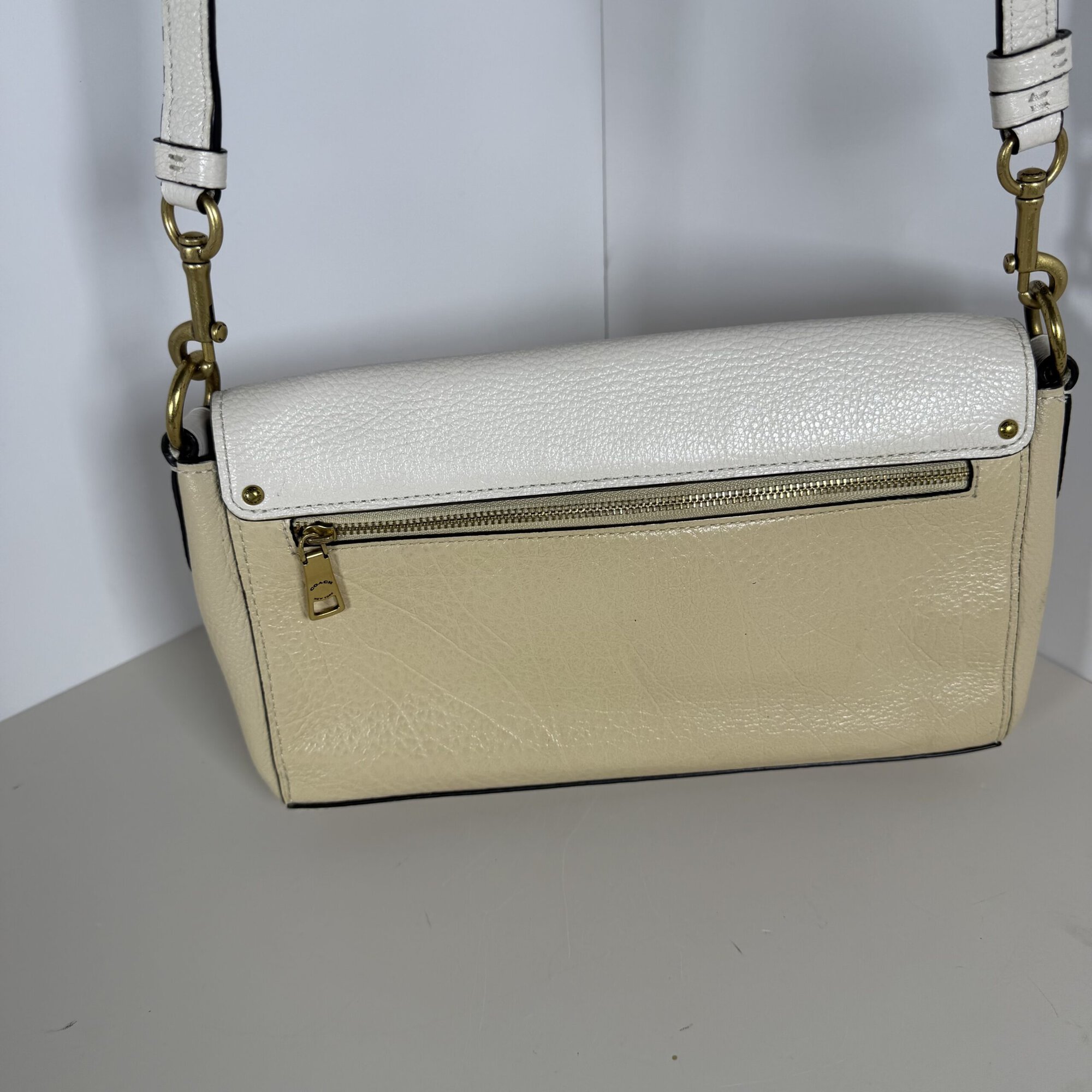 Rear exterior view of Coach Jade bag showing horizontal zipper pocket and strap attachments