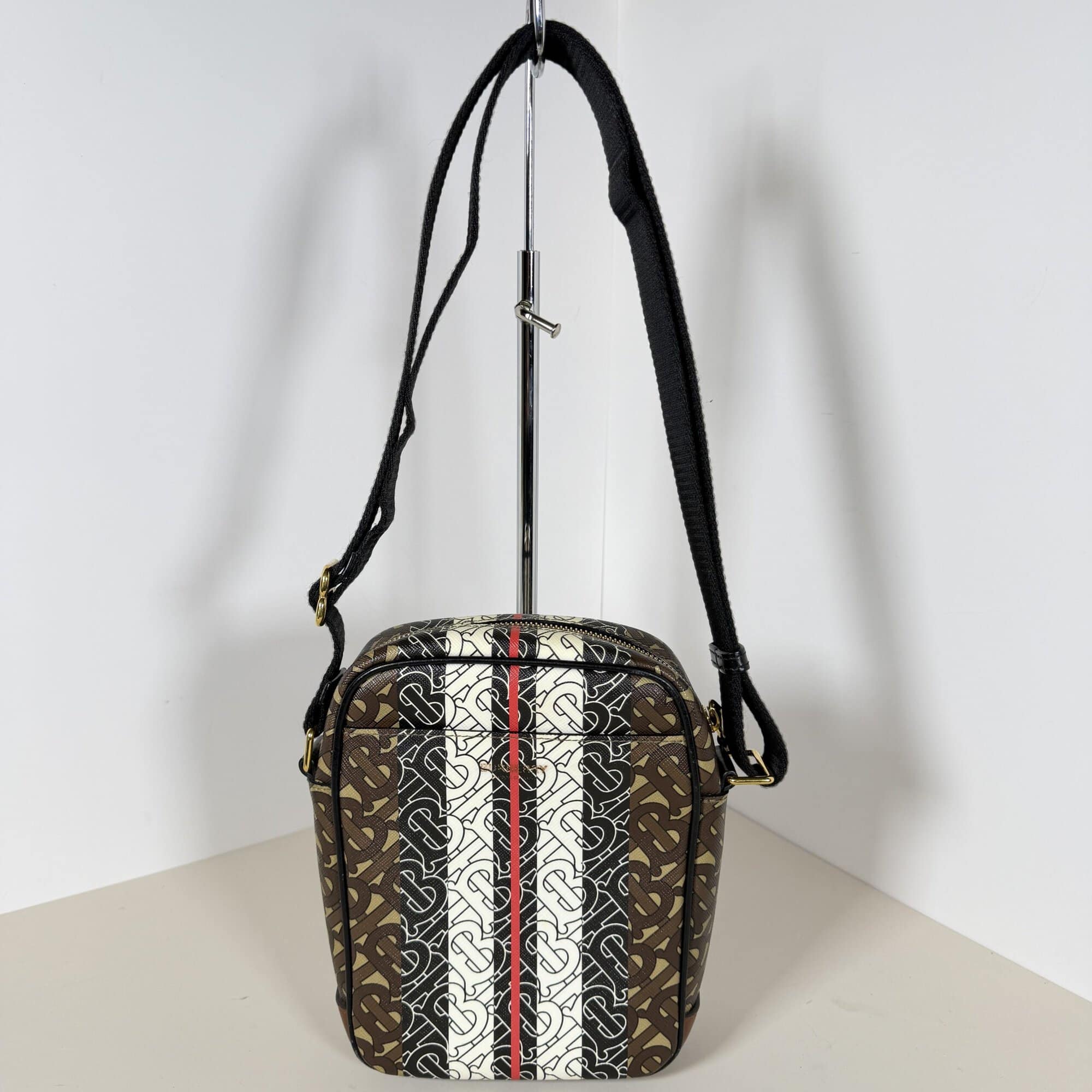 Burberry Monogram Stripe crossbody bag displayed on a stand from the front