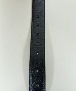 Tip of belt strap showing embossed Guccissima pattern and adjustment holes