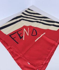 Fendi silk foulard scarf folded showing red corner with stylized script logo and black chevron stripes.