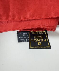 Close-up of Fendi foulard label and 100 percent silk care tag made in Italy along red rolled hem.