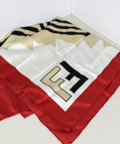 Folded Fendi silk scarf displaying bold FF block logo corner with red border and chevron pattern.