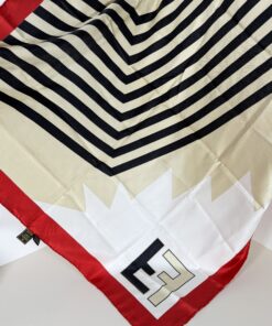 Overhead view of Fendi silk scarf spread open showing black and cream chevron center and red borders.