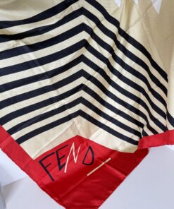 Fendi silk scarf spread showing script logo corner, striped chevron center, and red borders.